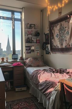 a dorm room with a desk, bed and window overlooking the cityscape in the distance