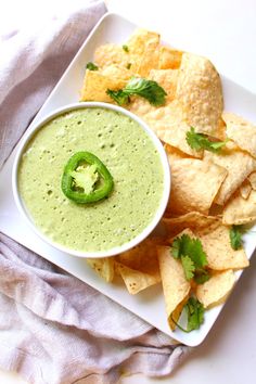 a white plate topped with chips and guacamole