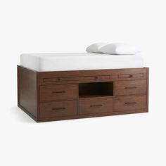 a bed with drawers and a white pillow