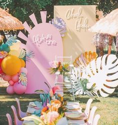 there is a table set up outside with balloons and decorations on the grass for an outdoor party