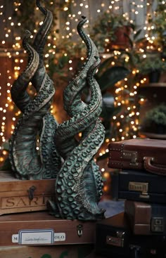 there are two statues that look like snakes on top of suitcases in front of a christmas tree