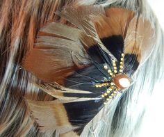 This bold black and gold feather fascinator is constructed of a fan of gold turkey feathers topped by a fan of black turkey feathers, accented with lines of gold rhinestones and a gold crystal. Turkey feathers are a symbol of pride. Show your pride at the next school function, pageant, or dance recital with this feather hair clip! The feather hair bow attaches easily in your hair with an alligator clip.   This design is easily customizable to your colors. Here are some other variations: https://www.etsy.com/listing/289897963/black-and-white-feather-hair-comb?ref=listings_manager_grid  Proudly made in the USA! Custom orders are my delight! I can customize any design (any number) just for you, or create something unique for your event... Just Give me a Convo. Together we can make something j Feather Hair Bows, Feather Hair Comb, Black Turkey, Feather Hair Pieces, Black Hair Bow, Black Hair Bows, Gold Hair Comb, Feather Tops, Feather Fascinator