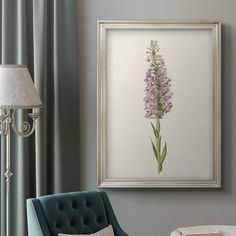 a living room with a blue chair and a painting hanging on the wall above it