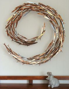 a metal wreath sitting on top of a wooden shelf next to a white rabbit figurine