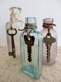 three glass bottles with keys attached to them