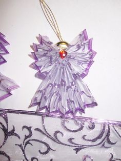 a purple angel ornament hanging on a white wall next to some decorative items