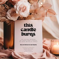 this candle burns sign is surrounded by flowers and candles on a table with a pink blanket