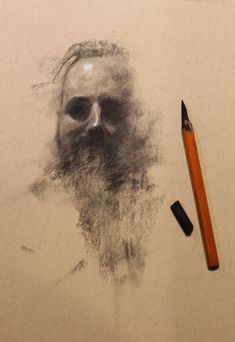 a pencil is next to a drawing of a man's face with a beard