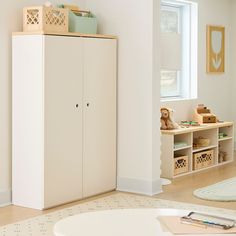 a child's room with white furniture and toys