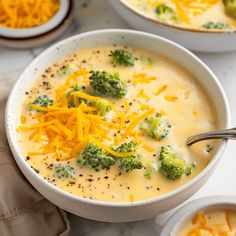 two bowls filled with broccoli cheese soup