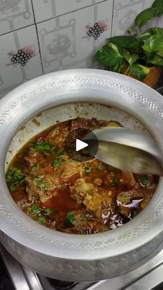 a bowl filled with soup sitting on top of a stove next to potted plants