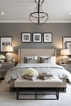 a bedroom with gray walls and pictures on the wall above the bed, along with two lamps