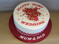 a white cake with red and gold decorations on it's side that says happy rix wedding mum & dad