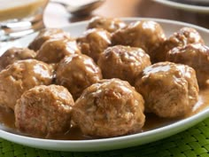 meatballs covered in gravy on a white plate