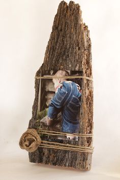 an old photo frame with a rope around it and a piece of wood in the middle