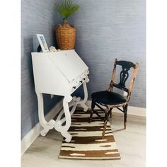 a white desk with a chair next to it and a potted plant on top