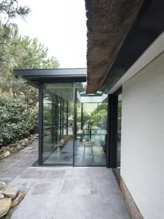 an outdoor room with glass doors and stone flooring