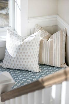 two pillows sitting on top of a window sill next to a radiator