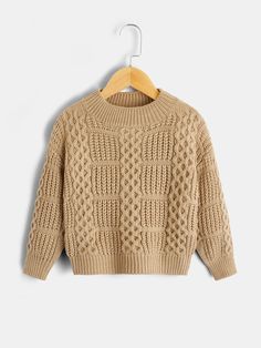 a beige sweater hanging on a hanger