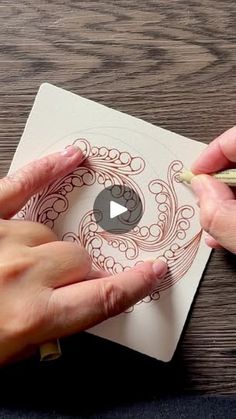 two hands are drawing on a piece of paper