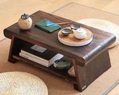 a coffee table with some books on it and a potted plant next to it