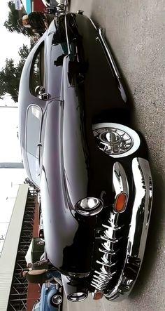 an old black car parked next to a building