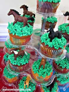 cupcakes with green frosting and horses on them are arranged in the shape of trees