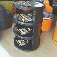 a stack of magazines sitting on top of a table next to orange trash canisters