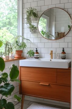 a bathroom with plants on the window sill and a round mirror above the sink