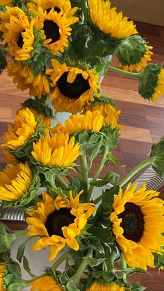 a vase filled with lots of yellow sunflowers