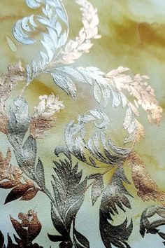 an image of a gold and silver wallpaper with flowers on it's side