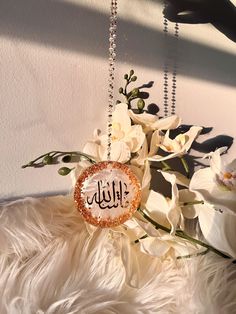 a close up of a flower on a white fur covered surface with the word hello written in arabic