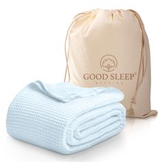 a blue blanket sitting next to a bag on top of a white surface with the words good sleep written on it