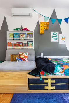 a room with a bed, couch and bookshelf on the wall above it