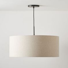 a light fixture hanging from the ceiling in a room with white walls and flooring