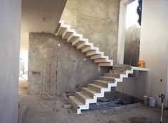 an unfinished room with stairs and construction equipment