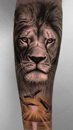 a man's leg with a lion and bird tattoo on the calf area,