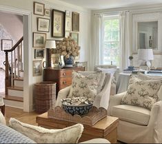 a living room filled with furniture and pictures on the wall