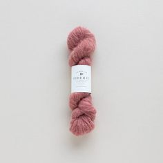 a skein of pink yarn sitting on top of a white surface