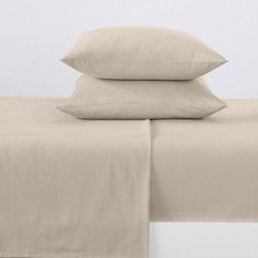 three pillows and two pillow cases on a bed