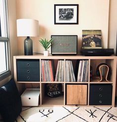 a record player is sitting on top of a bookcase in front of a window