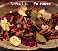 an apple cider potpouri in a wooden bowl with cinnamons, apples and cranberries