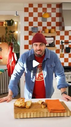 a man standing in front of a cutting board with food on it