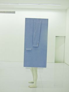 a person is standing in an empty room with a blue piece of cloth on their head