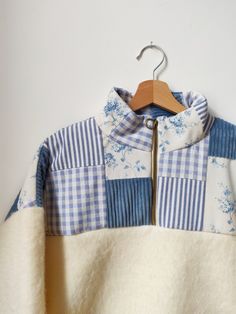 a blue and white jacket hanging on a wooden hanger