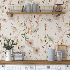 a laundry room with floral wallpaper and baskets on the shelves