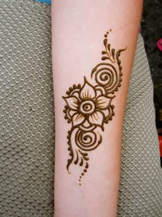 a woman's arm with a henna tattoo on it