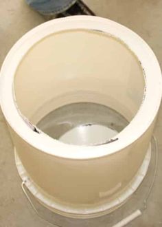 a white toilet bowl sitting on top of a floor next to a person with blue jeans