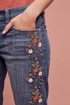 someone is showing off their jeans with embroidered flowers on the bottom and side, but no one has seen them before