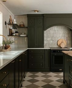 a kitchen with green cabinets and checkered flooring